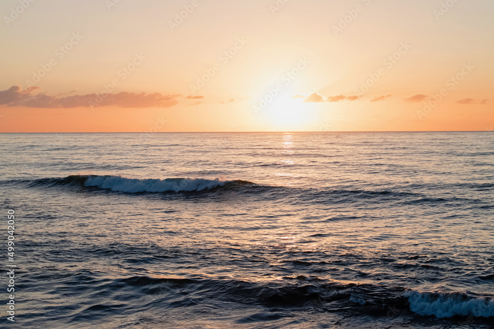 Sunset over the the ocean with small waves