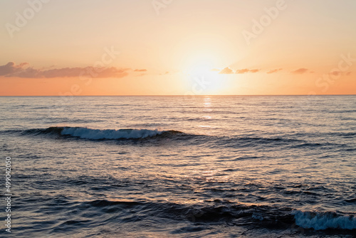 Sunset over the the ocean with small waves