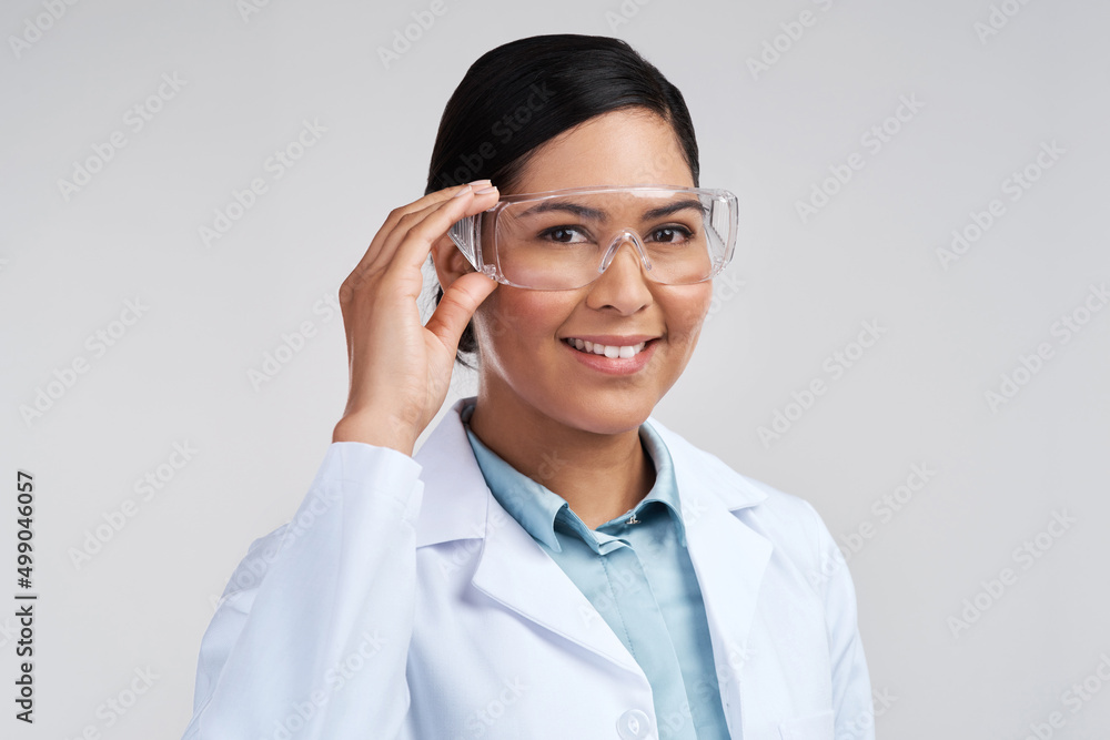 Ready to get to work. Cropped portrait of an attractive young female scientist wearing goggles in studio against a grey background. Ready to get to work. Cropped portrait of an attractive young female scientist wearing goggles in studio against a grey background.