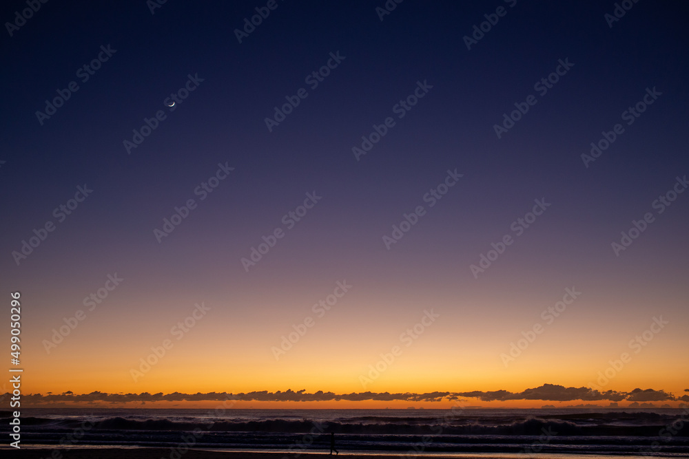 Sunrise Quarter Moon Over Ocean Walker Orange and Dark Blue Sky Surf Beach Gold Coast Australia