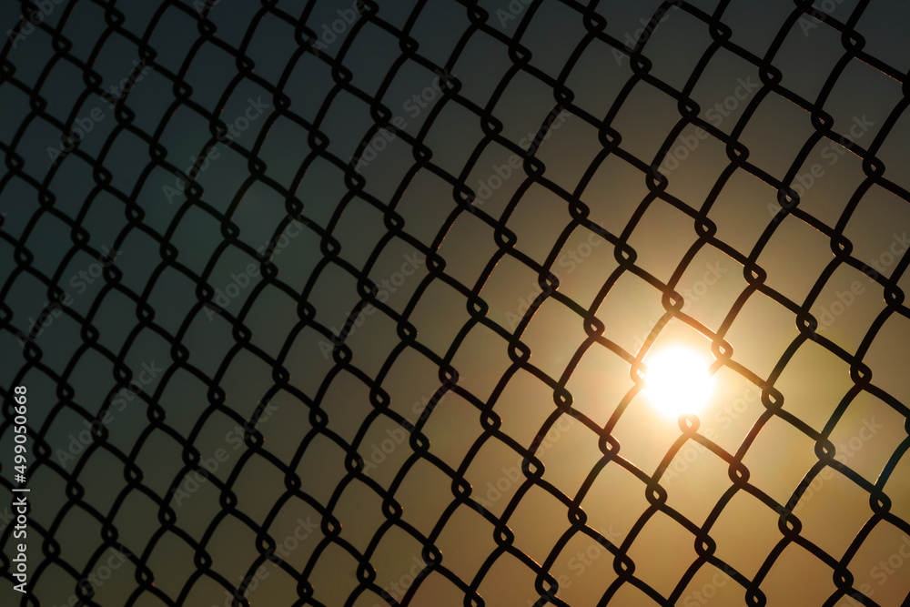 Sunset through the fence. Sunset through the fence.