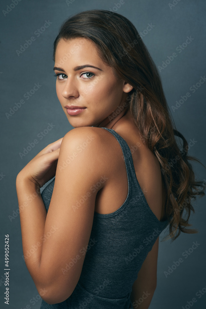 Gorgeous and flawless. Studio shot of a beautiful young woman posing against a blue background. Gorgeous and flawless. Studio shot of a beautiful young woman posing against a blue background.