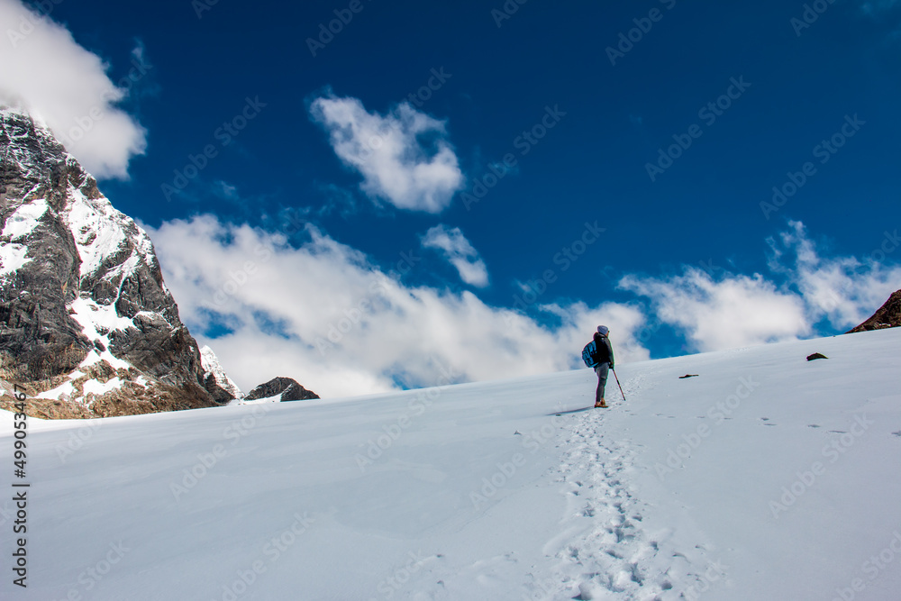 Hiker in the snowy Raura in Oyon - Peru. A person near a snowy peak.