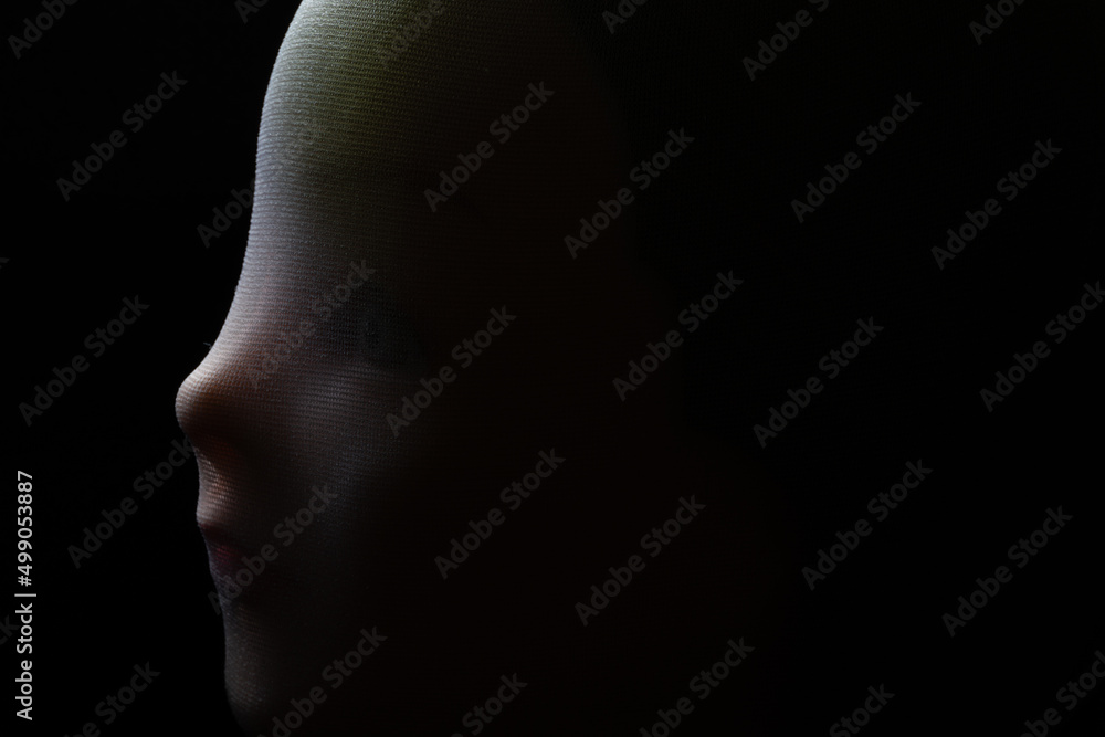 A girl doll isolated on black background with copy space.