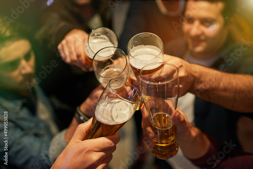 Boys night. High angle shot of guys toasting with beers at a party. photo