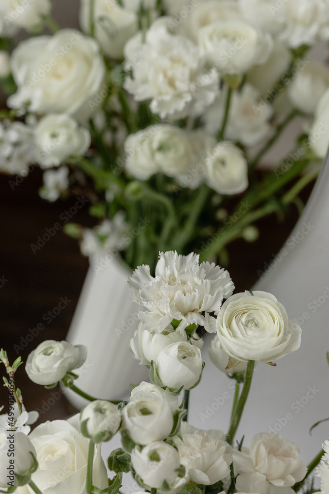 Composition of white flowers in a vase on a chest of drawers Composition of white flowers in a vase on a chest of drawers