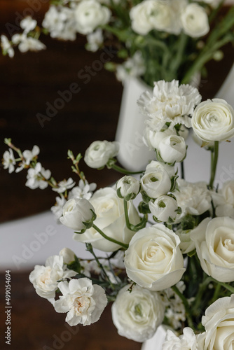 Composition of white flowers in a vase on a chest of drawers
