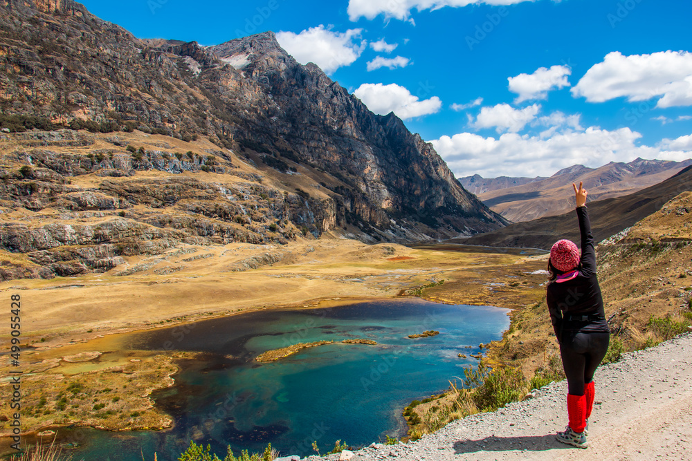 Fototapeta premium Hiker in Mountainous landscape with lagoon and blue sky with clouds in the background.
