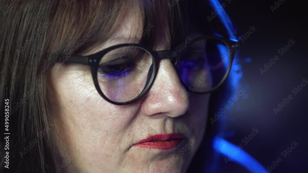 A close-up of an adult woman wearing glasses, her glasses reflect an online stock market chart showing Bitcoin currencies. In real time. Cryptocurrency. Investors A close-up of an adult woman wearing glasses, her glasses reflect an online stock market chart showing Bitcoin currencies. In real time. Cryptocurrency. Investors