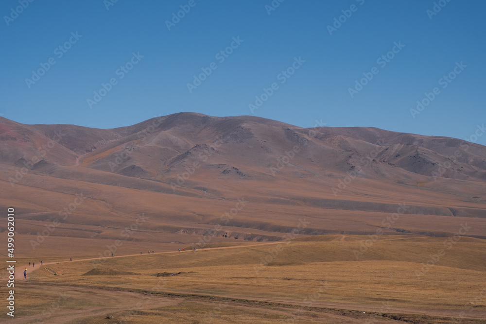 Group of cyclists are riding bikes on mountain plateau. Cycle tour on Assy plateau. Travel, tourism in Kazakhstan concept.