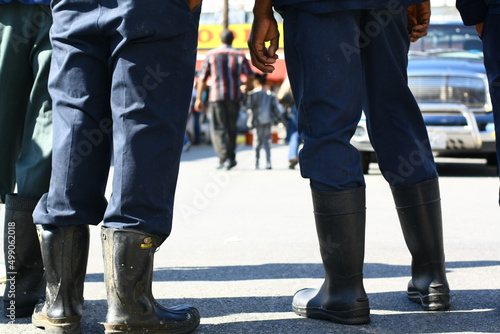 men standing and waiting wearing rubber boots