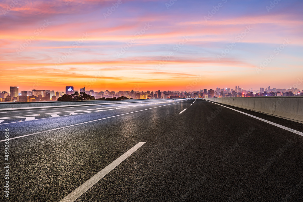 Asphalt road and city skyline with beautiful sky clouds at sunrise in Hangzhou, China.