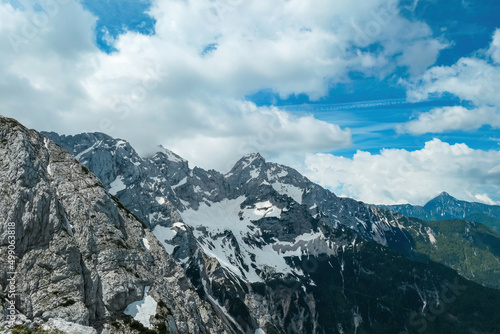 Scenic view from Mala Baba on rocky, sharp, cloud and snow covered mountain summit peaks of Kamnik Savinja Alps in Carinthia, border Austria Slovenia. Spring in Vellacher Kotschna. Via Ferrata. Breath © Chris