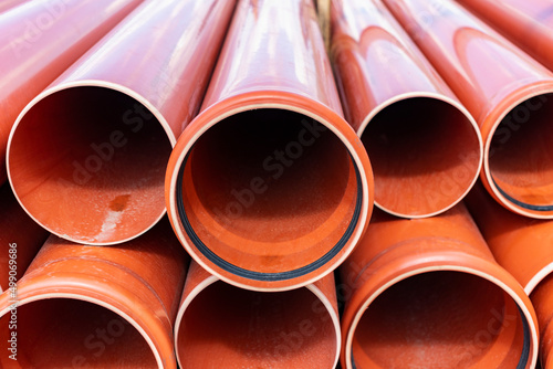 Orange sewer pipes at the construction site. Preparation for the installation of an underground sewer system. Wastewater disposal. © Anoo