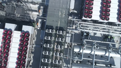 Overhead look down. Datacenter roof with rooftop fans, piping and tanks of HVAC aircon cooling system.