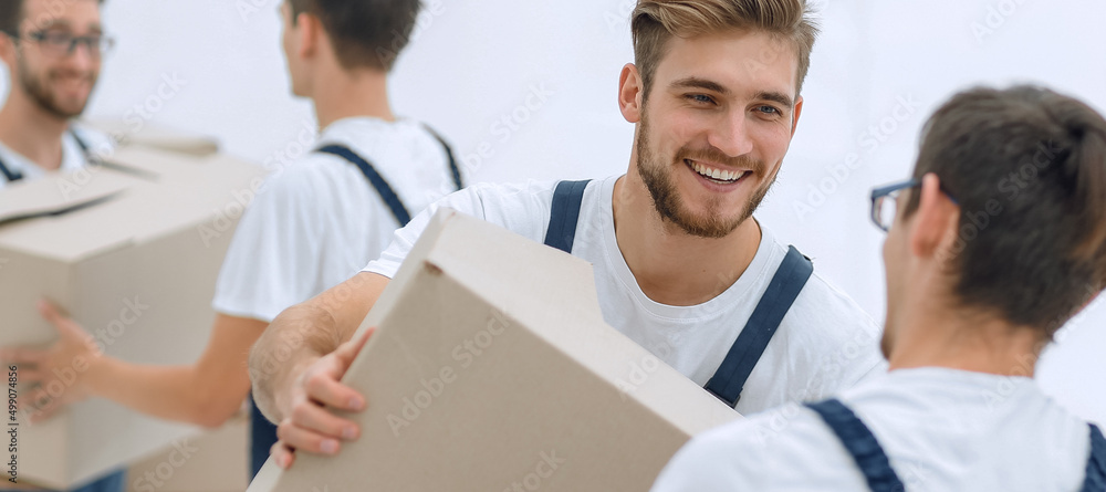 Portrait of movers holding box smiling isolated on white backgro Portrait of movers holding box smiling isolated on white backgro