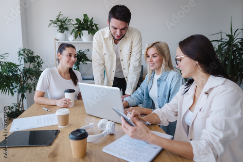 Millennial employees gathered in boardroom for training, man leading corporate team