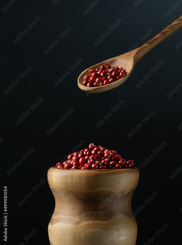 Dry fragrant pink pepper in a bowl, red pepper spice.