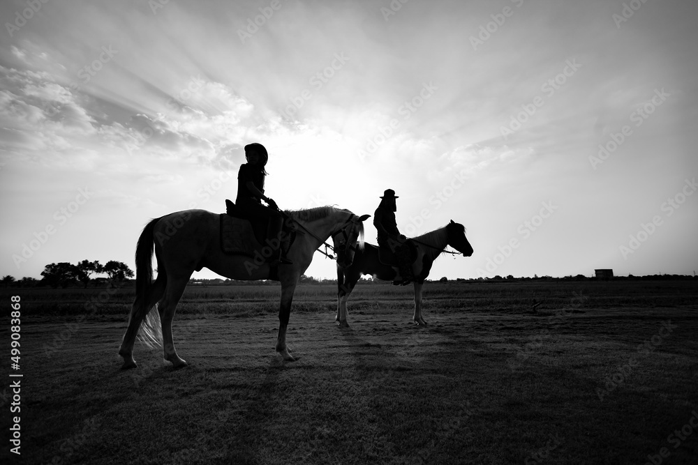 Children riding horse at sunset