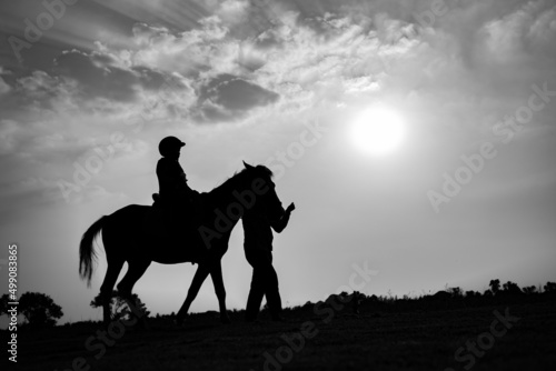 Silhouette of child riding horse in the farm © khamkula