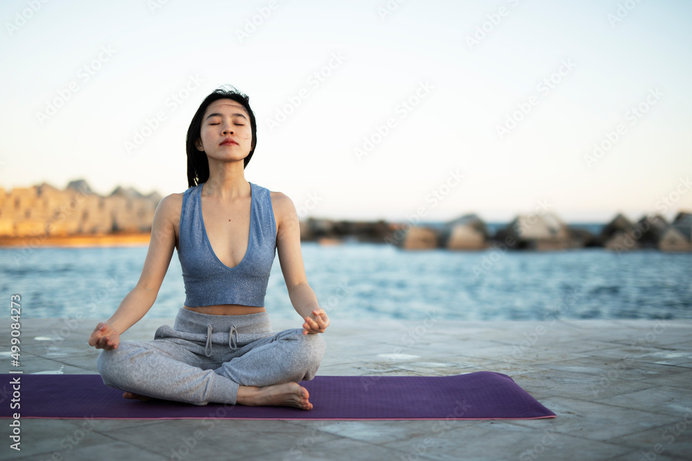 Beautiful young woman stretching outside. Fit woman doing yoga exercise.. Beautiful young woman stretching outside. Fit woman doing yoga exercise..