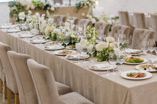 Tables setting at a luxury wedding. Table for guests. Dishes and drinks. Wedding table preparation.