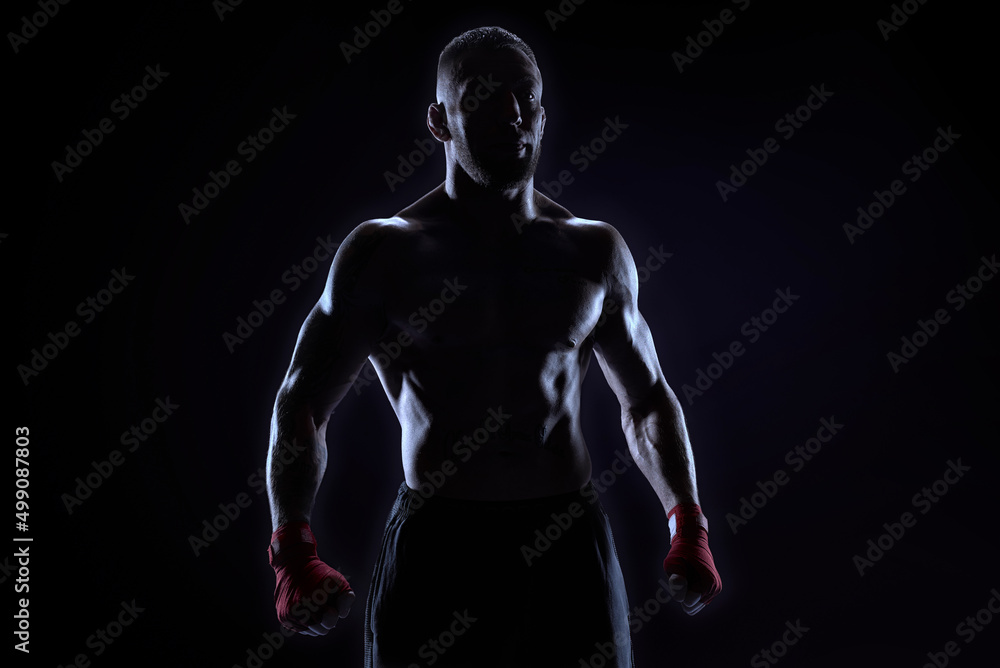 Kickboxer in red bandages posing on a blue background. The concept of mixed martial arts. Kickboxer in red bandages posing on a blue background. The concept of mixed martial arts.