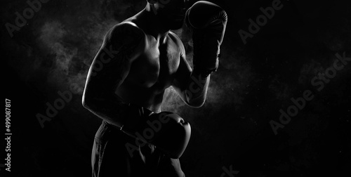 Noname image of a kickboxer on a dark background. The concept of mixed martial arts. photo