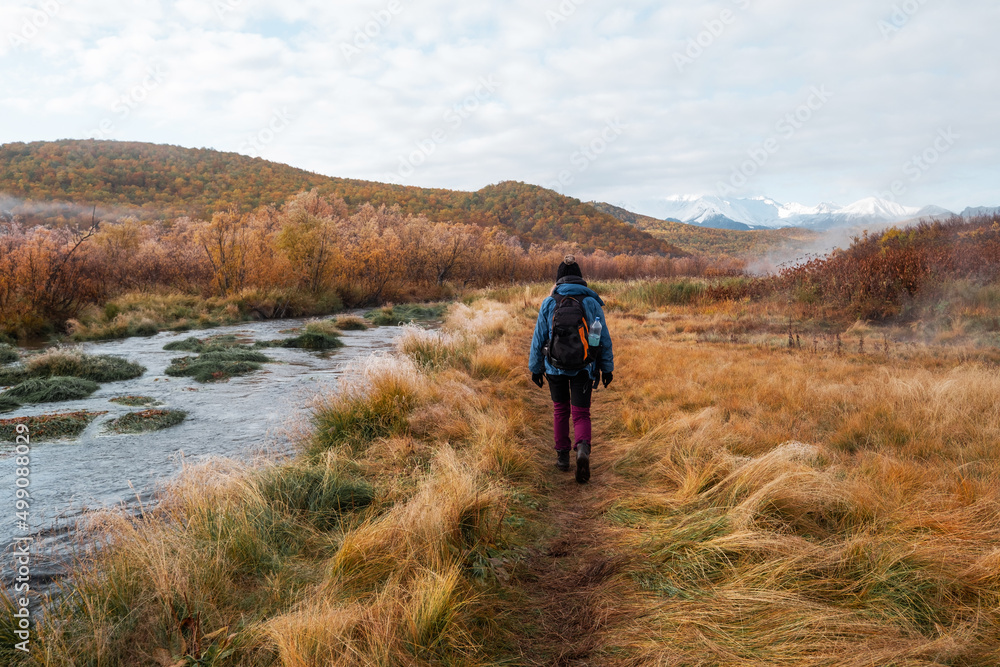 Obraz premium Female walking in mountains, autumn landscape, the first frost on the grass, sunny frosty day, bright colors of nature