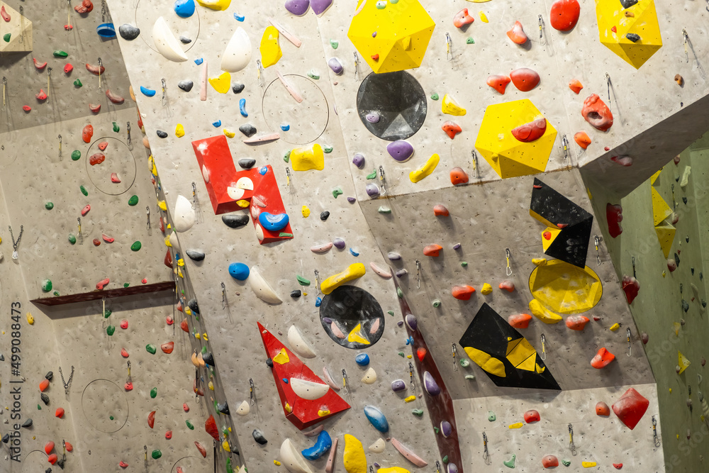 Artificial rock climbing wall with various colored grips.