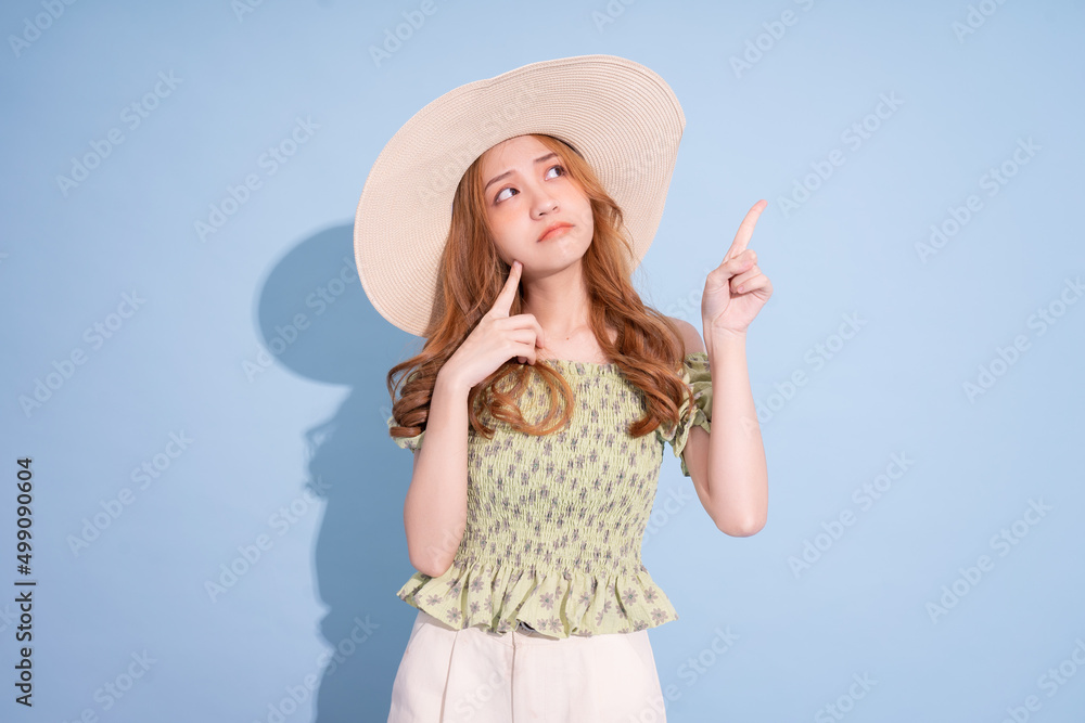 Portrait of young Asian girl wearing hat on blue background Portrait of young Asian girl wearing hat on blue background
