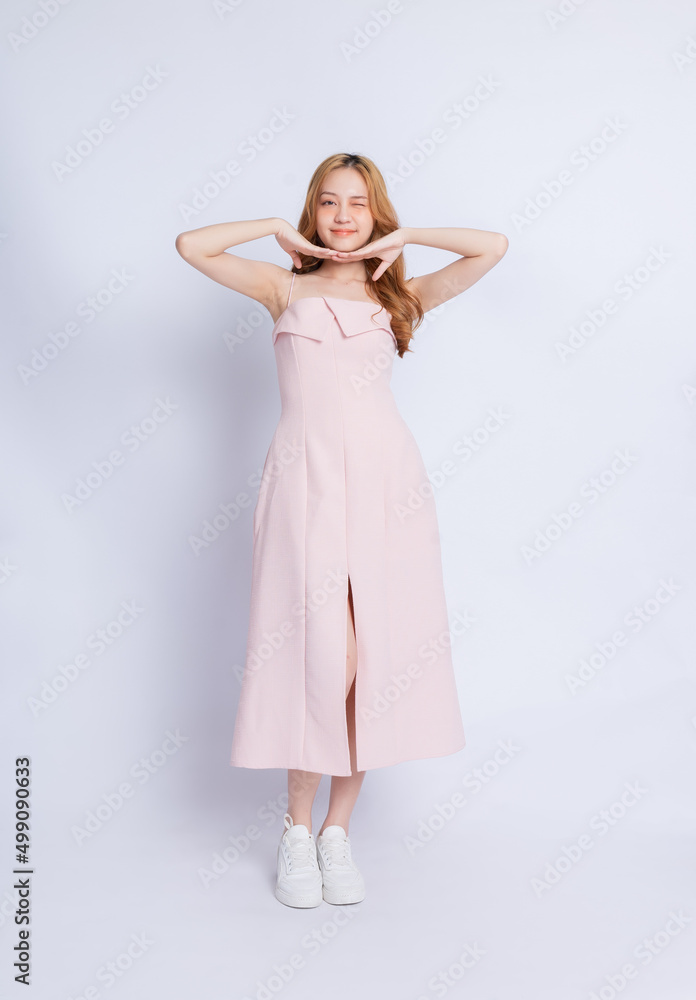 Naklejka premium Full length image of young Asian woman wearing dress on white background