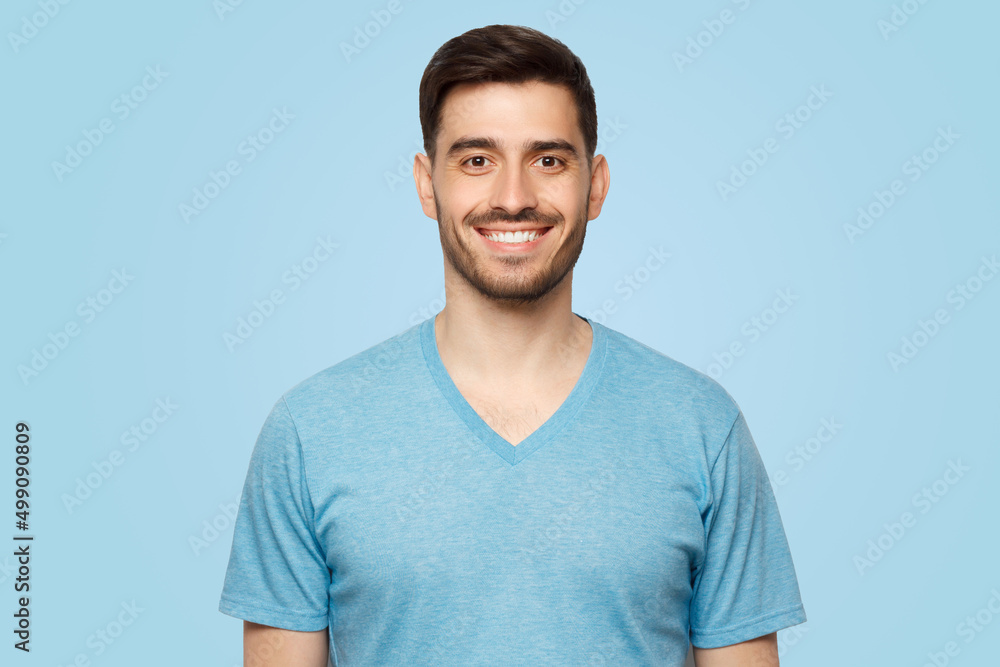 Obraz premium Close-up portrait of young smiling handsome male with short dark hair and stubble