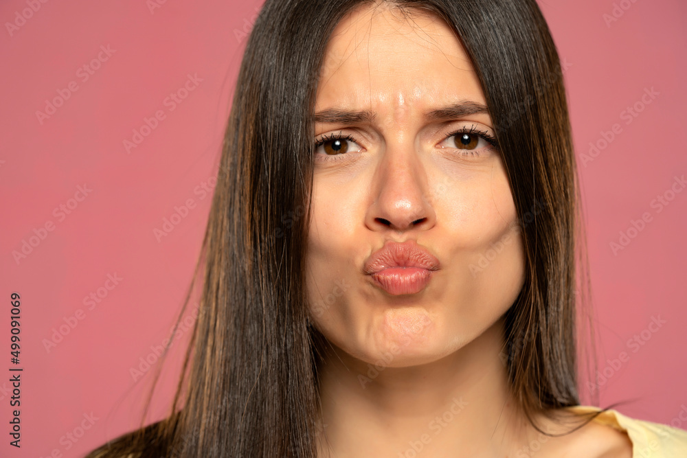 Young beautiful woman with kissing gesture on a pink background Young beautiful woman with kissing gesture on a pink background