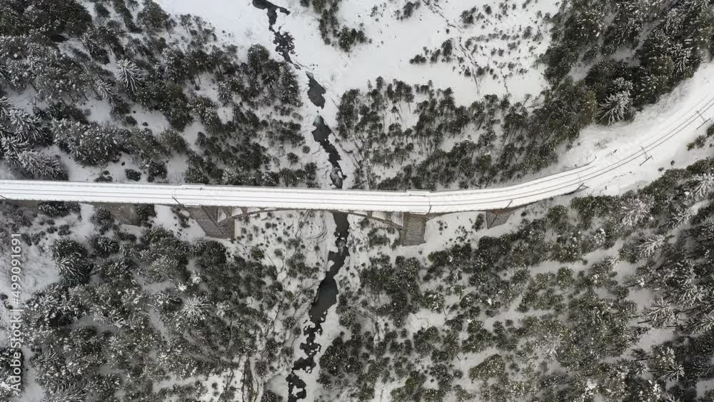 Aerial shot of a viaduct in the mountains covered with snow Aerial shot of a viaduct in the mountains covered with snow