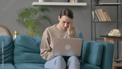 Woman with Laptop Feeling Worried on sofa