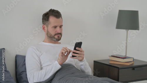 Man using Smartphone in Bed