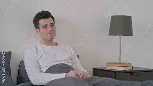 Man Feeling Worried while Sitting in Bed