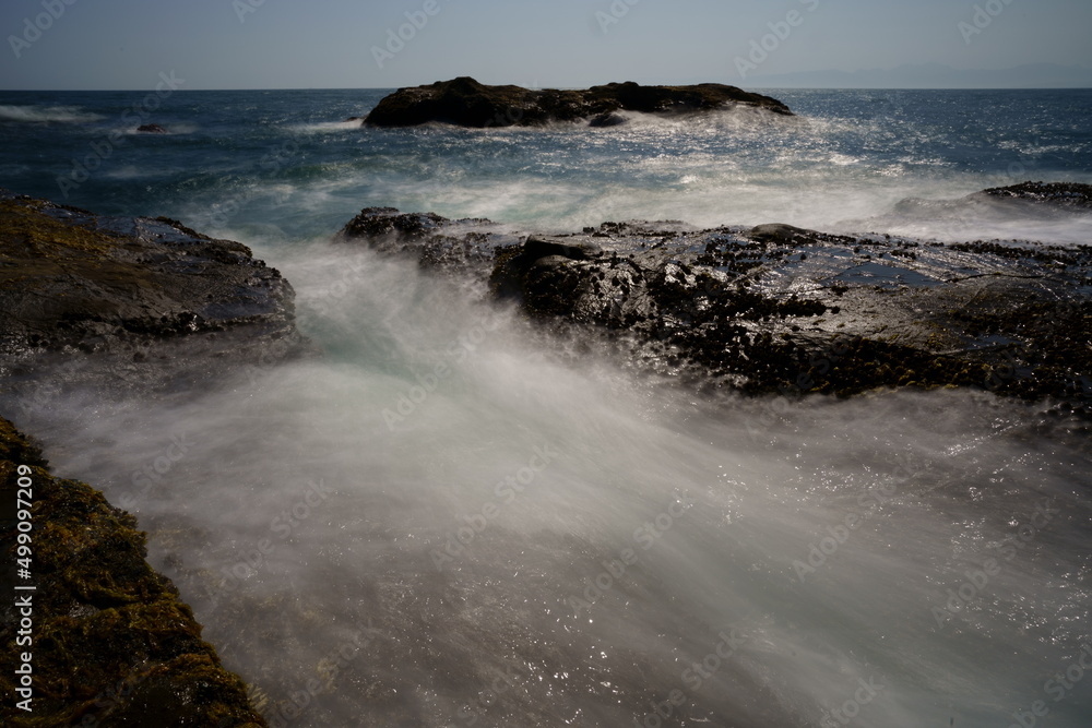 波が打ち寄せる岩場の海岸の風景をスローシャッターで撮