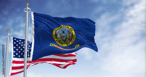 Foto The Idaho state flag waving along with the national flag of the United States of