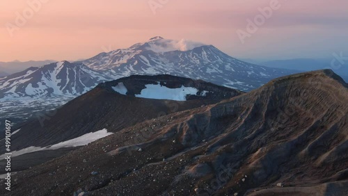 View of Mutnovsky volcano from the crater of Gorely volcano. Kamchatka peninsula, Russia. Aerial drone view. Beautiful landscape at sunrise. photo