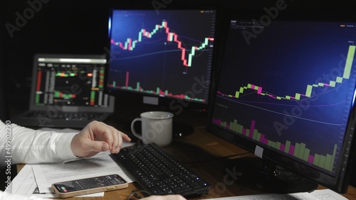 Close-up of a man's hands at a computer with an online stock market chart showing bitcoin currencies. In real time. Cryptocurrency. Investors