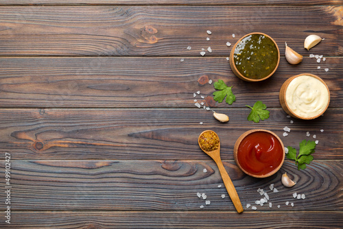 Different sauces in spoons on table background, flat lay top view