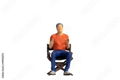 Miniature people sitting on chair isolated on white background and clipping path 