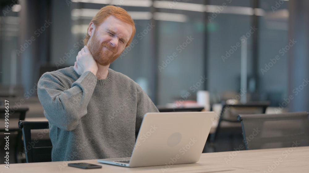 Young Man having Neck Pain while using Laptop in Office Young Man having Neck Pain while using Laptop in Office