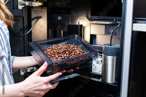 Maintenance of modern coffee machines. Loading coffee beans.