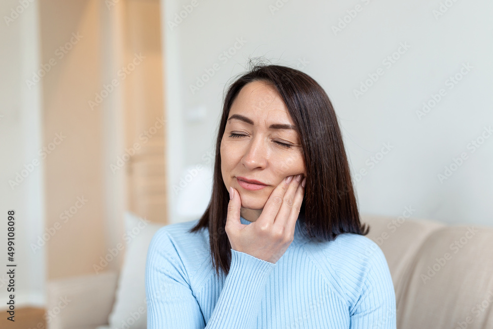 Portrait of unhappy Asian woman suffering from toothache at home. Healthcare, dental health and problem concept. Stock photo Portrait of unhappy Asian woman suffering from toothache at home. Healthcare, dental health and problem concept. Stock photo
