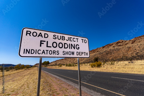 Flood warning sign on outback Australian road. Alice Springs, Northern Territory.