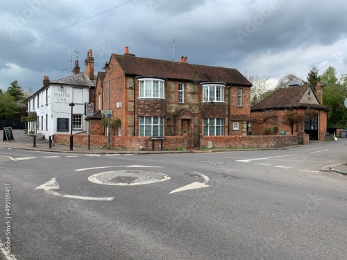 Roundabout view connecting The Pound and Terry’s lane in Cookham, Berkshire, England. Street view of medieval village. Roundabout on the Pound street, old brick cottage on a front side, The white oak photo