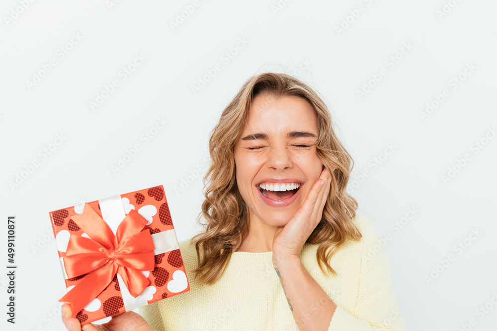 Cheerful blonde young woman holding gift box laugh Cheerful blonde young woman holding gift box laugh